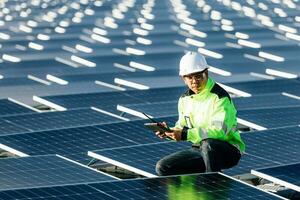 The portrait of a young engineer checks photovoltaic solar panels. Concept. renewable energy technology electricity service, green power. photo