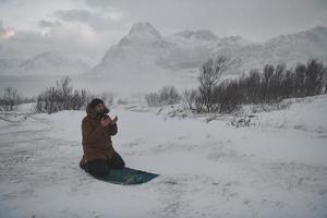Muslim traveler praying in cold snowy winter day photo