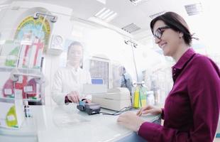 pharmacist suggesting medical drug to buyer in pharmacy drugstore photo