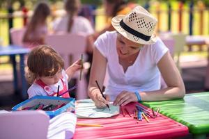 mom and little daughter drawing a colorful pictures photo