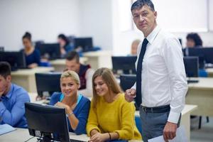 students with teacher  in computer lab classrom photo