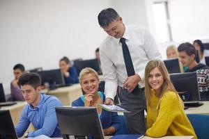 students with teacher  in computer lab classrom photo