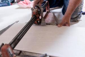 worker cutting the ceramic wood effect tiles photo