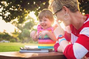 mom and her little daughter using tablet computer photo
