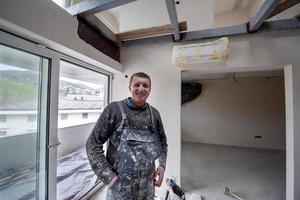 retrato de trabajador de la construcción con uniforme sucio en apartamento foto