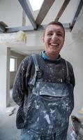 retrato de trabajador de la construcción con uniforme sucio en apartamento foto