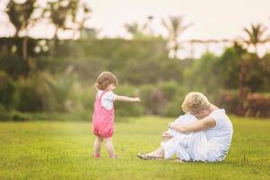 mother and little daughter playing at backyard photo