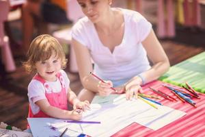 mom and little daughter drawing a colorful pictures photo