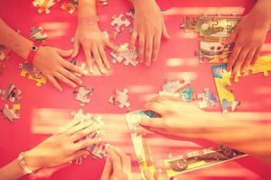 top view of kids hands playing with puzzles photo