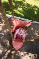 little girl swinging  on a playground photo