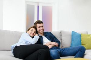 young couple watching tv at home in bright living room photo