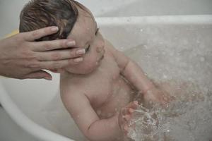 cute little baby girl taking a bath photo