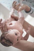 Newborn baby girl taking a  bath photo