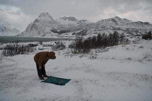 Muslim traveler praying in cold snowy winter day photo