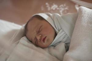 newborn baby sleeping in  bed at hospital photo