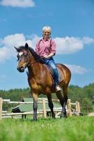 mujer feliz montar a caballo foto