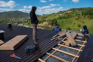 trabajador de la construcción instalando un nuevo techo foto