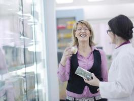 pharmacist suggesting medical drug to buyer in pharmacy drugstore photo