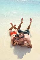 feliz pareja joven divertirse en la playa foto