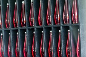 botellas de jugo rojo en un restaurante moderno foto