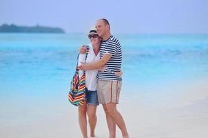 feliz pareja joven divertirse en la playa foto