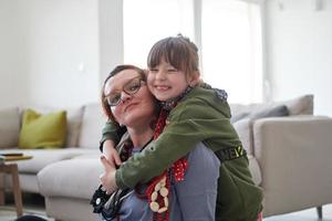 madre e hija pequeña jugando con joyas en casa foto