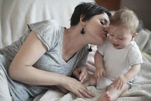 la madre está jugando con el bebé en casa foto