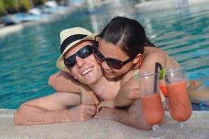 happy young couple relax and take fresh drink on poolside photo