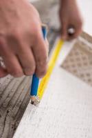 worker installing the ceramic wood effect tiles on the floor photo