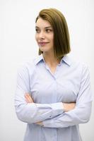 foto de retrato de una hermosa mujer de negocios rubia parada con los brazos cruzados en un fondo blanco aislado.