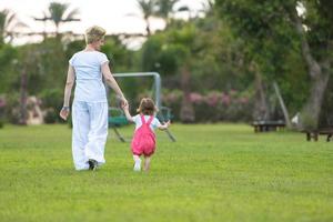 mother and little daughter playing at backyard photo