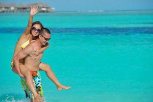 happy young  couple enjoying summer on beach photo