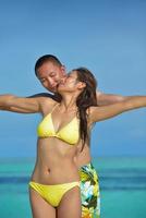 feliz pareja joven disfrutando del verano en la playa foto