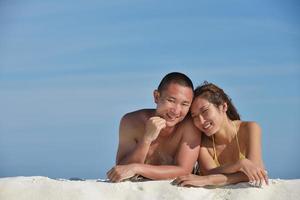 asian couple enjoying summer on beach photo
