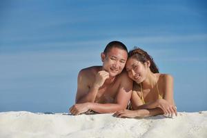 asian couple enjoying summer on beach photo