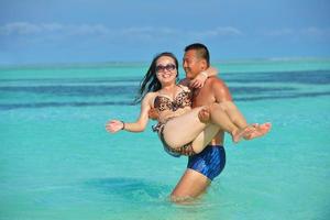 feliz pareja joven disfrutando del verano en la playa foto