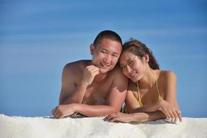 feliz pareja joven disfrutando del verano en la playa foto