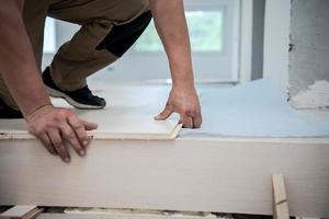 Worker Installing New Laminated Wooden Floor photo