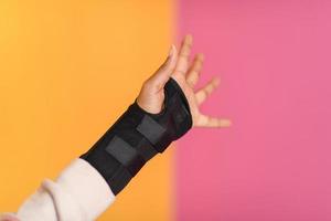hand injury. a female injured hand on a yellow background photo