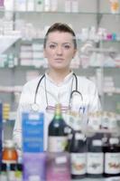 pharmacist chemist woman standing in pharmacy drugstore photo