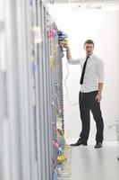 young engeneer in datacenter server room photo