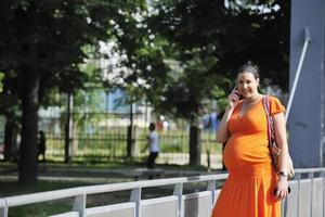 mujer embarazada feliz hablando por celular foto