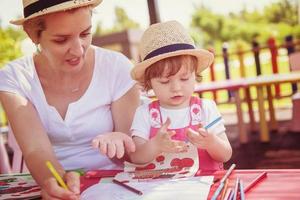 mom and little daughter drawing a colorful pictures photo