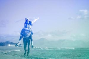 pareja divirtiéndose en la playa durante el otoño foto