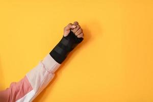 hand injury. a female injured hand on a yellow background photo