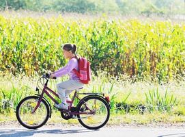 colegiala que viaja a la escuela en bicicleta foto
