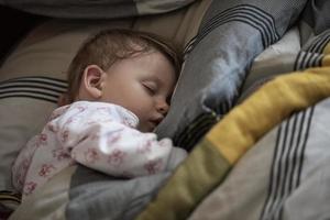 newborn baby sleeping  at home in bed photo