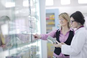 Farmacéutico sugiriendo drogas médicas al comprador en farmacia droguería foto