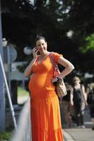 happy pregnant woman talking by cellphone photo