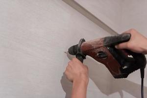 construction worker drilling holes in the bathroom photo